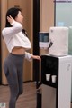 A woman standing in front of a water dispenser.