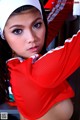 A woman in a red and white cheerleading uniform posing for a picture.