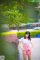 A woman in pink overalls posing for a picture.