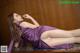 A woman in a purple dress laying on the floor.