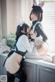 A couple of women in bunny costumes sitting on top of a kitchen counter.