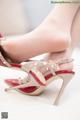 A close up of a woman's feet wearing a pair of red and beige shoes.