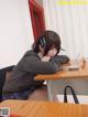 A woman sitting at a desk with her head on her hand.