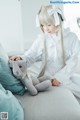 A woman sitting on a couch holding a stuffed animal.