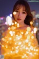 A woman standing in front of a bunch of lights.