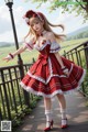 A woman in a red and white dress is posing for a picture.